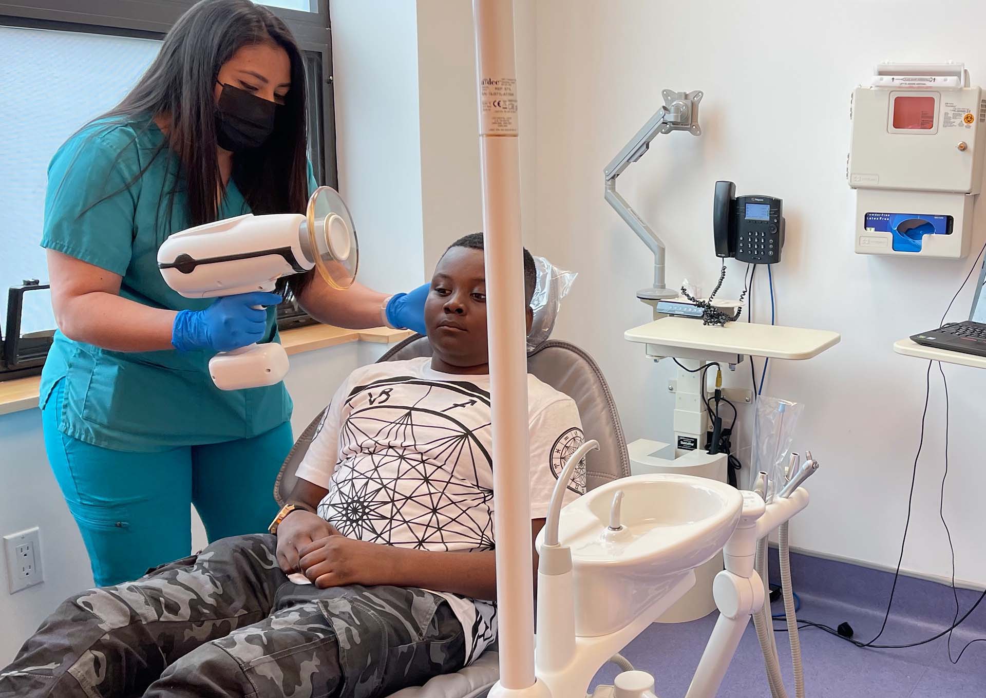 Dentist using handheld scanner on a patient